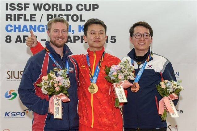 Hui Zicheng (centre), winner of the men's 50m rifle three positions event, with silver medallist Matthew Emmons (left) and bronze medallist Han Jinseop (right) on the podium ©ISSF